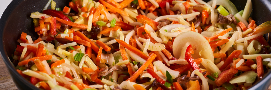 Close up of carrots, onions, peppers, and mushrooms mixed together for a vegetarian stir fry.