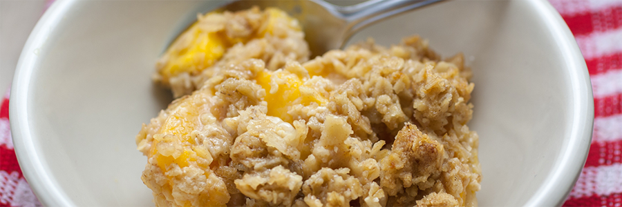 Shot of baked oatmeal with diced peaches.