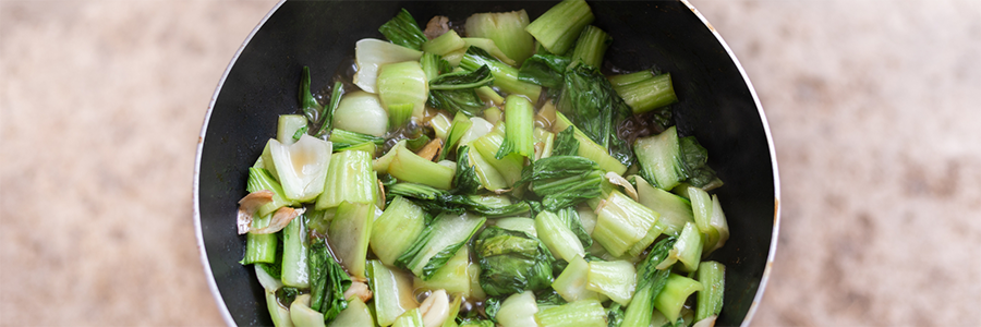 Close up of stir-fried bok choy in a sauce.