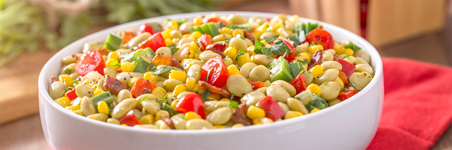 Shot of succotash with a medley of vegetables including lima beans, tomatoes, and corn.