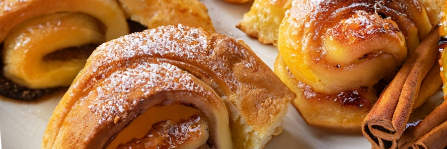Close up shot of peach pastries garnished with confectioners sugar.