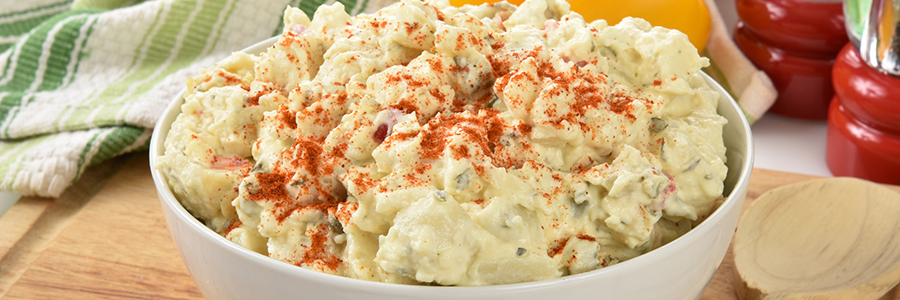 Close up shot of southern potato salad garnished with paprika.