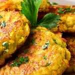 Plate of acorn squash fritters garnished with parsley.