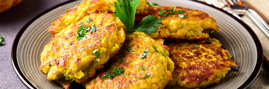 Plate of acorn squash fritters garnished with parsley.