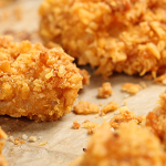 Wide shot of crispy chicken nuggets on a baking sheet.