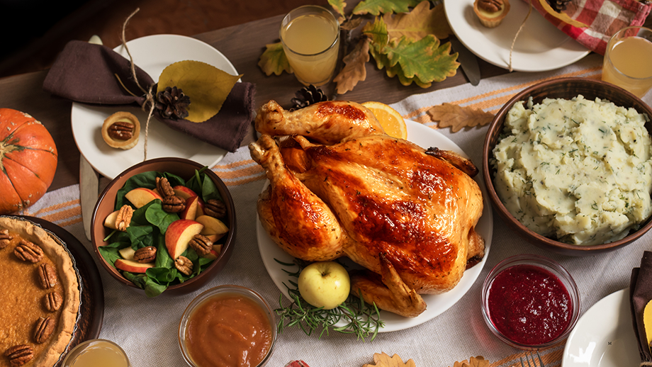 Thanksgiving spread with turkey, cranberry sauce, pie, and mashed potatoes.