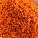 Overhead shot of a small white bowl with ground chili powder.