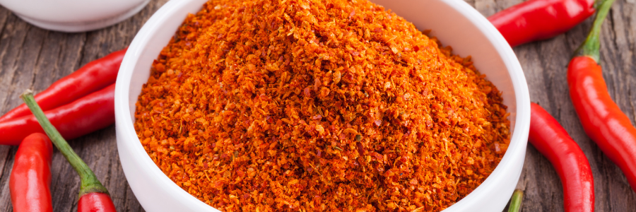 Overhead shot of a small white bowl with ground chili powder.
