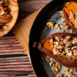 Overhead shot of a table with roasted sweet potatoes topped with brown sugar and pecans.