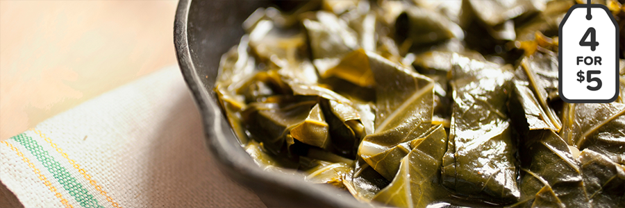 Shot of sautéed collard greens in a cast iron pan.