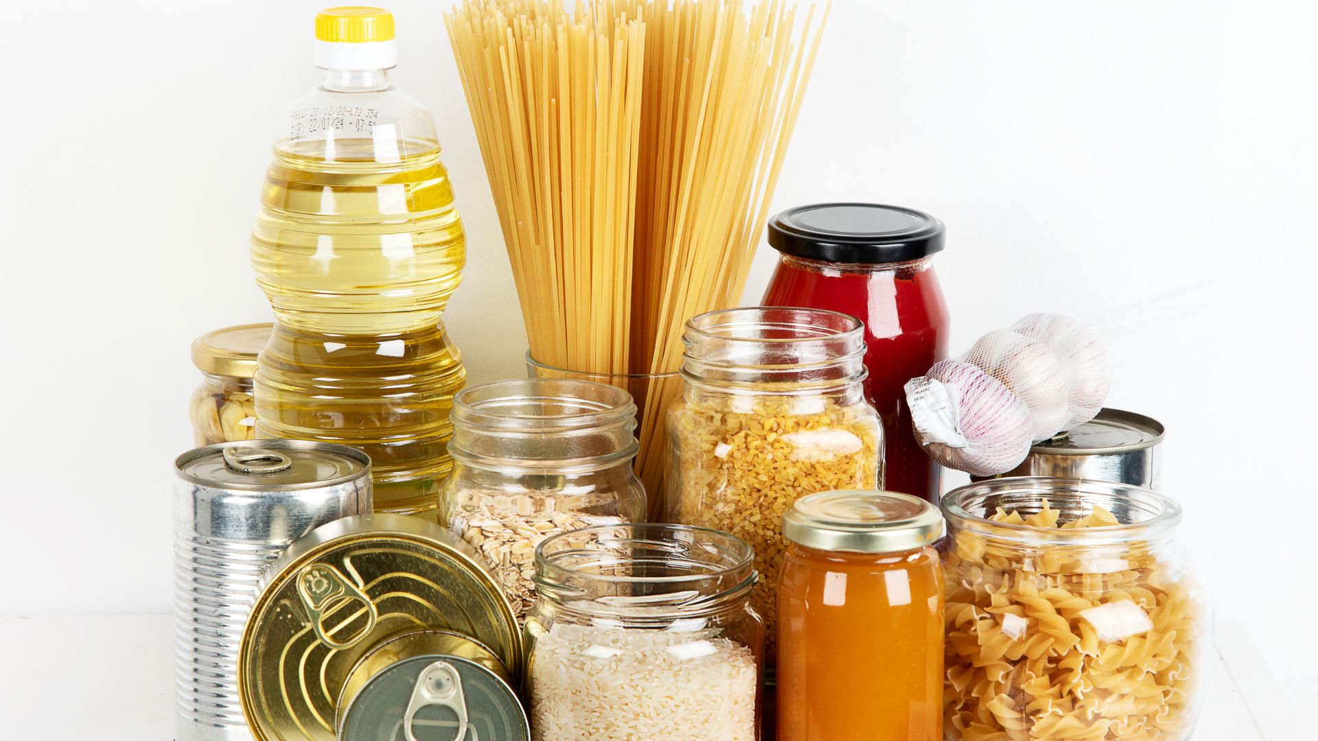 Collection of common pantry items like canned goods, jarred sauces, oats, rice and pasta.