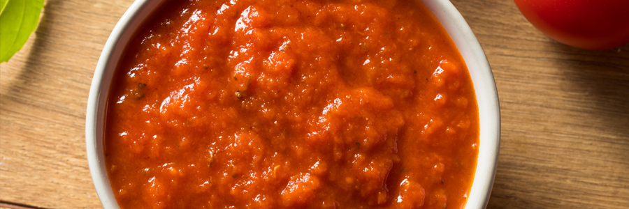 Close up of a red sauce on a wooden table