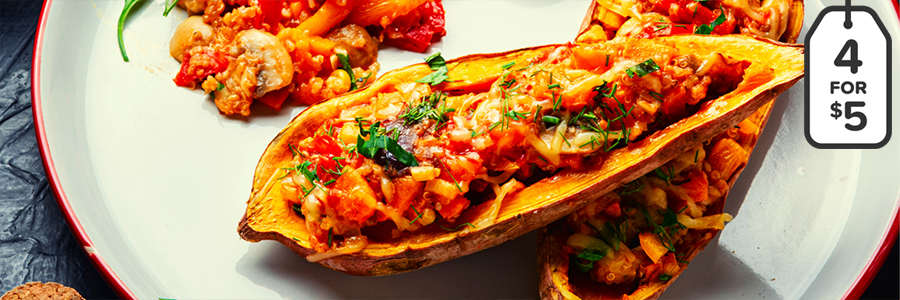 White platter with halved sweet potatoes topped with salsa, black beans, and cheese.