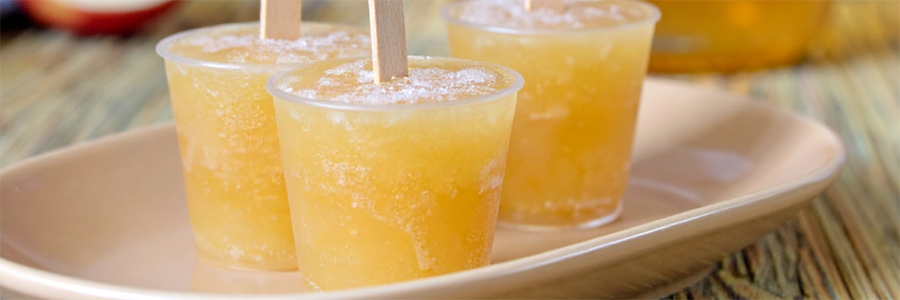 Plate of homemade popsicles made in clear small cups and popsicle sticks.