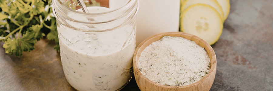 Wood ramekin with spice mix, displayed next to a jar of ranch dressing.